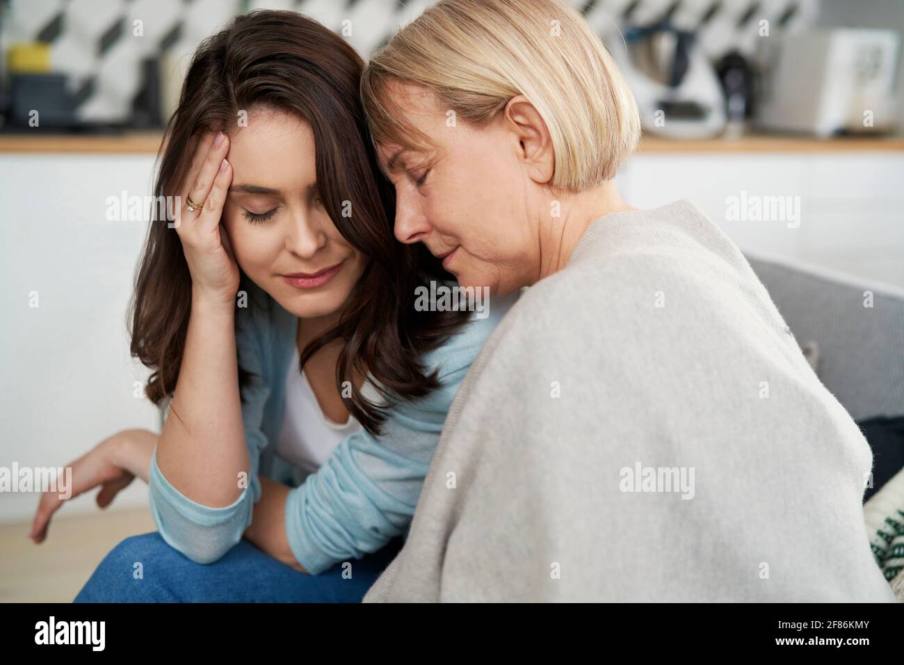 Mother and adult daughter in a comforting embrace Stock Photo