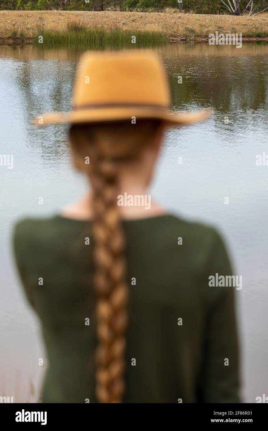 Woman with long braid in hat at lakeside Stock Photo