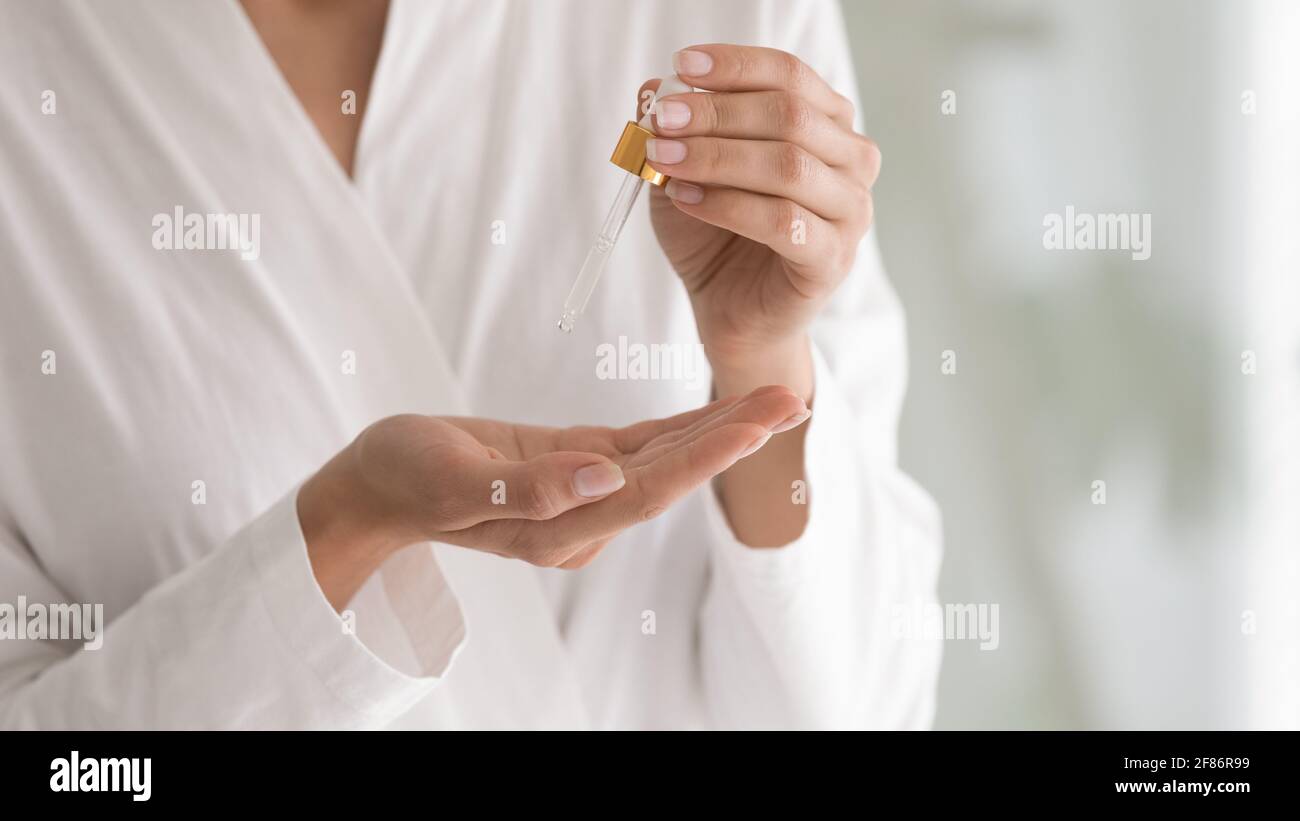 Cropped close up woman holding bottle with cosmetics moisturizing serum Stock Photo