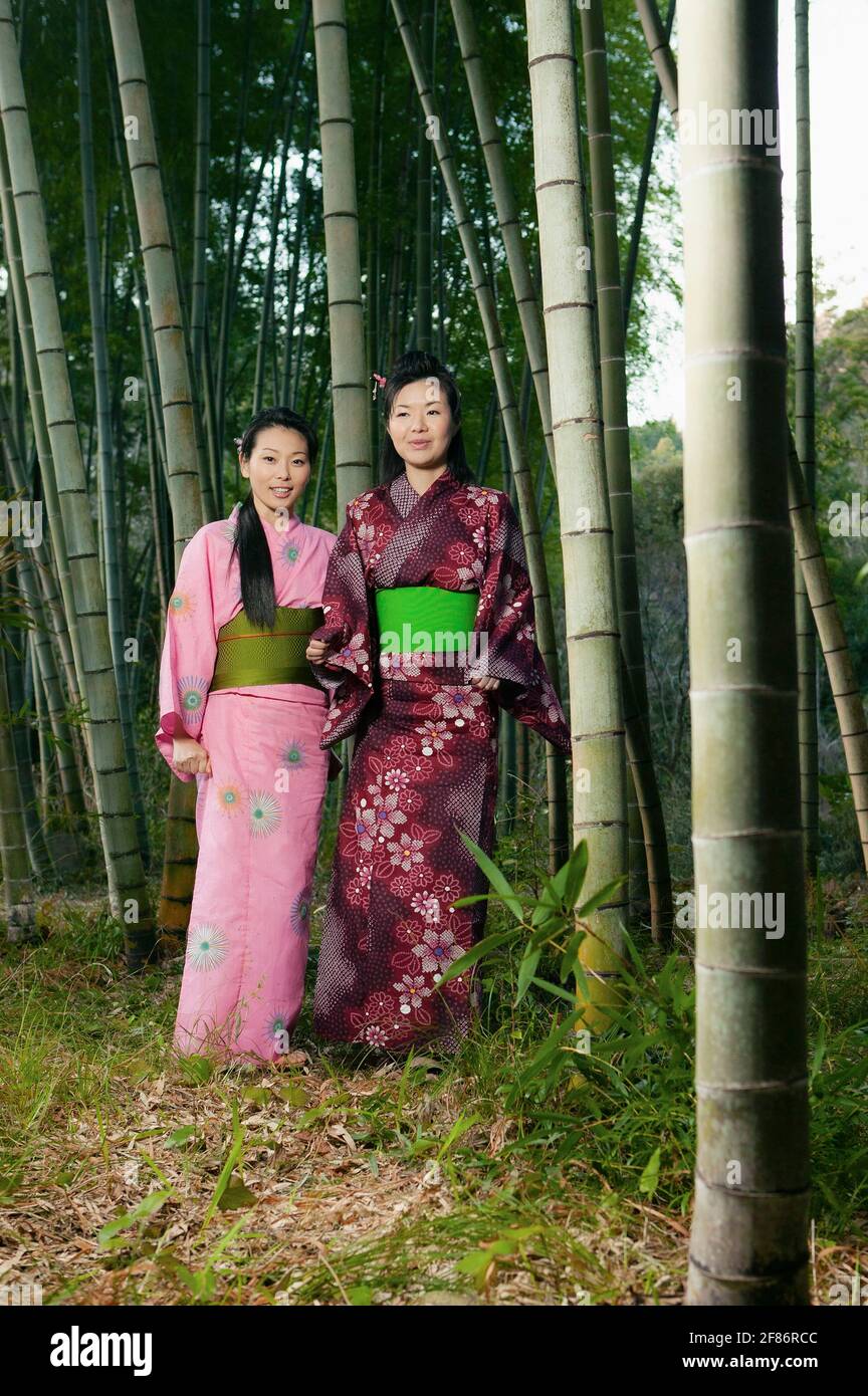 Portrait beautiful young women in Japanese kimonos among bamboo trees Stock Photo