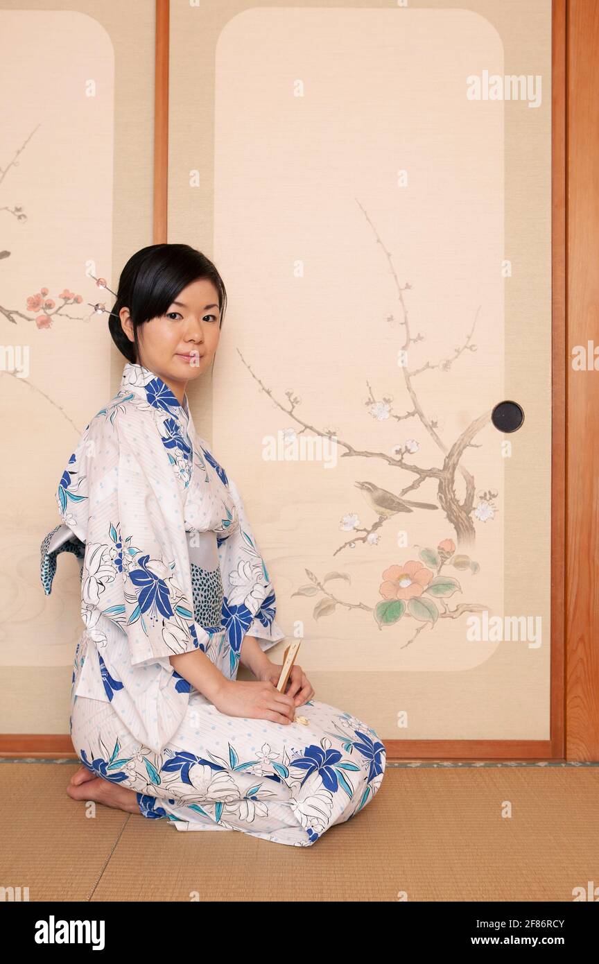 Portrait beautiful young Japanese woman in kimono at painted door Stock Photo