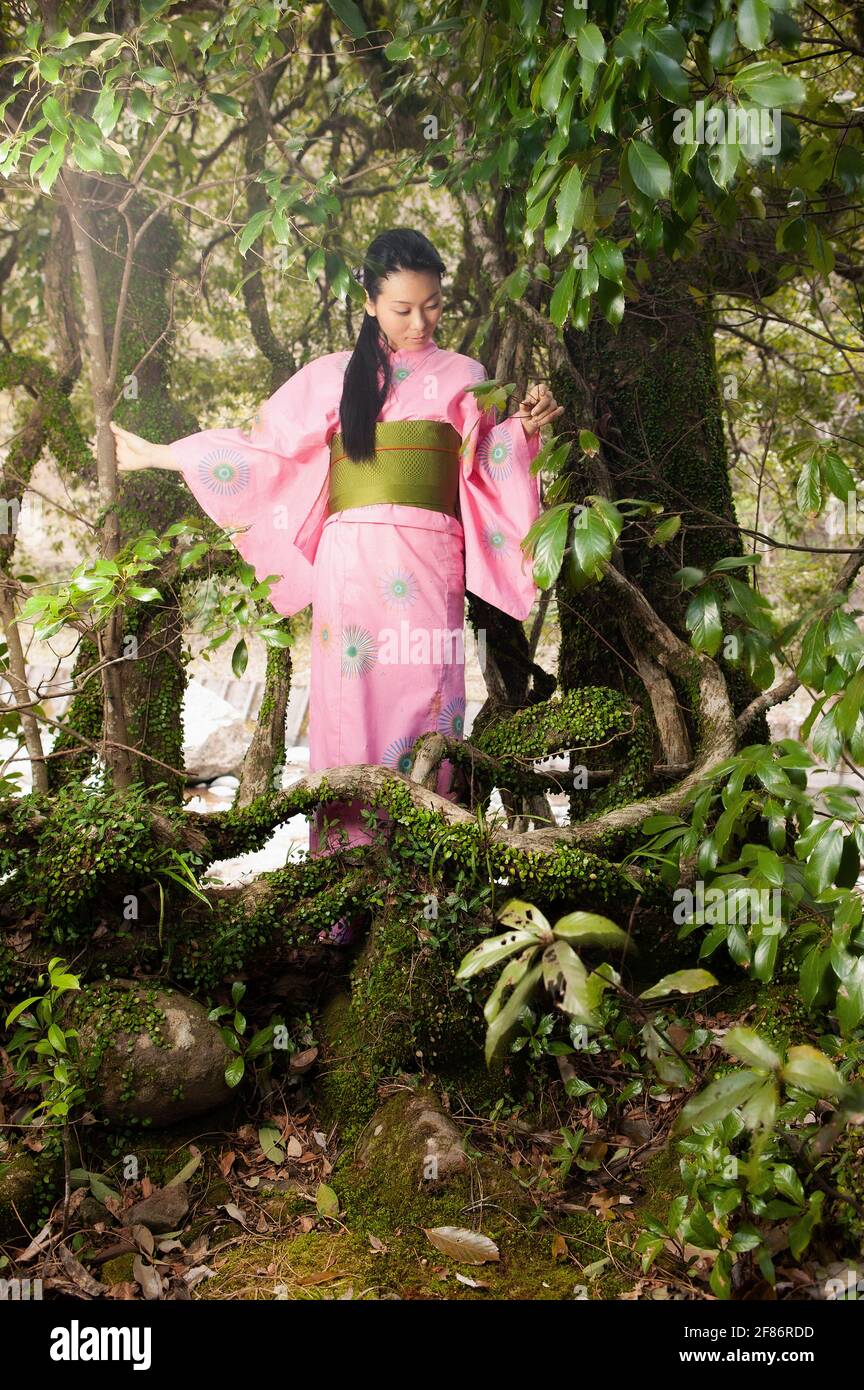 Young woman in pink kimono among beautiful trees Stock Photo