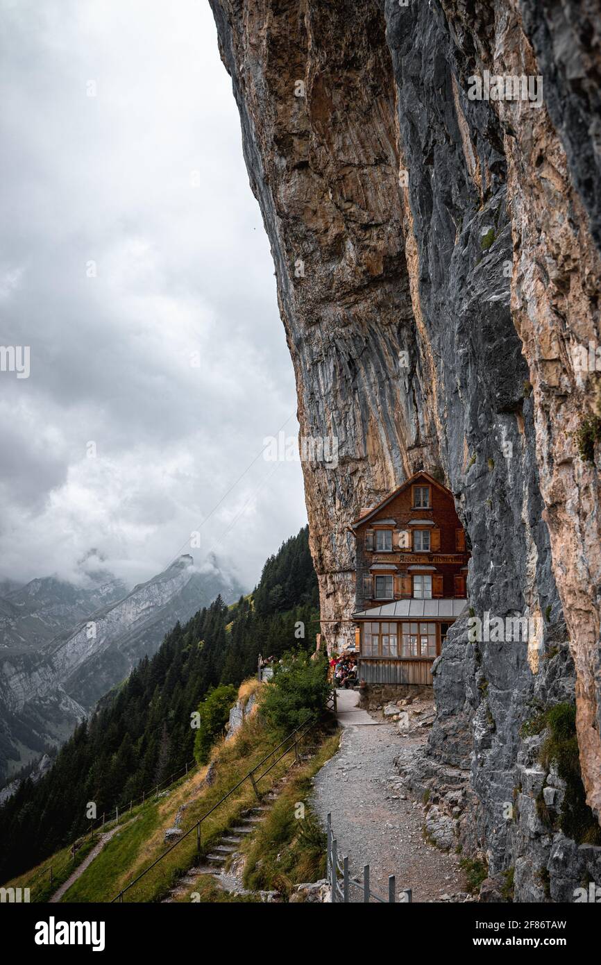 Typical mountain hut in the Alps (Aescher lodge) right next to a high rock  formation on a cloudy and moody day (Appenzell, Switzerland, Europe Stock  Photo - Alamy