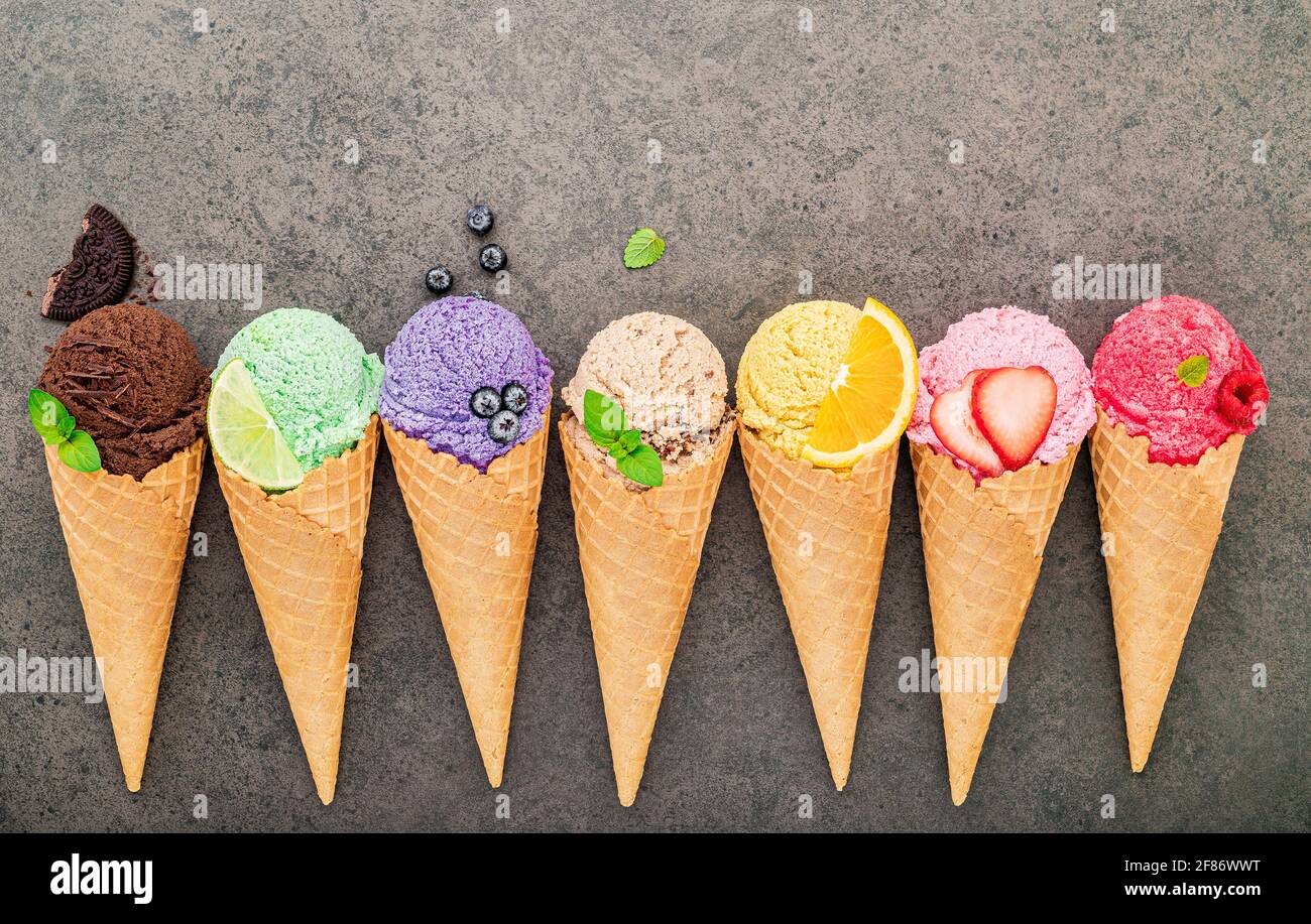 Flat lay ice cream cones collection on dark stone background . Blank crispy ice cream cone with