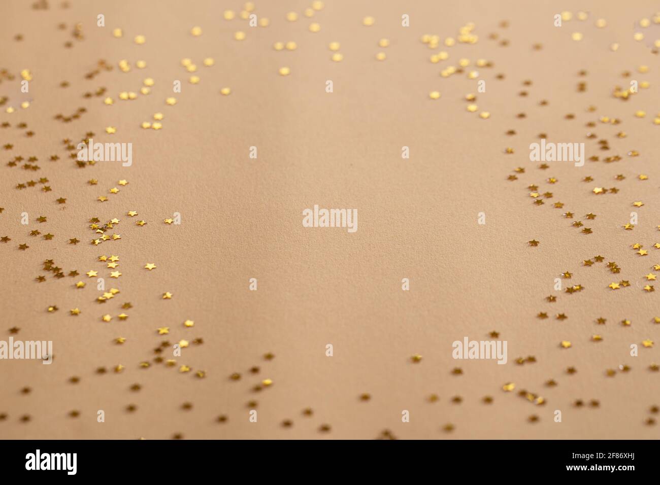 Golden sparkles stars on gold holiday background. Festive backdrop for your projects Stock Photo