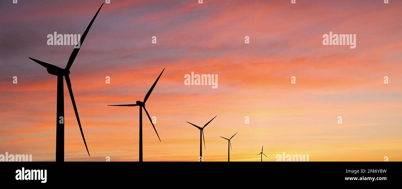 Silhouettes of wind turbines at sunset Stock Photo