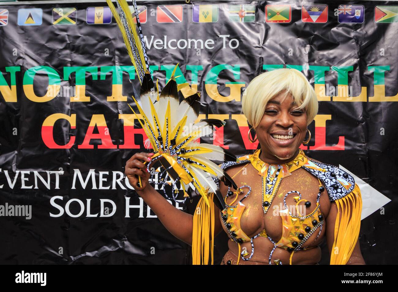 Afro-Caribbean female carnival participant in salsa costume, smiling at Notting Hill Carnival, London, England Stock Photo