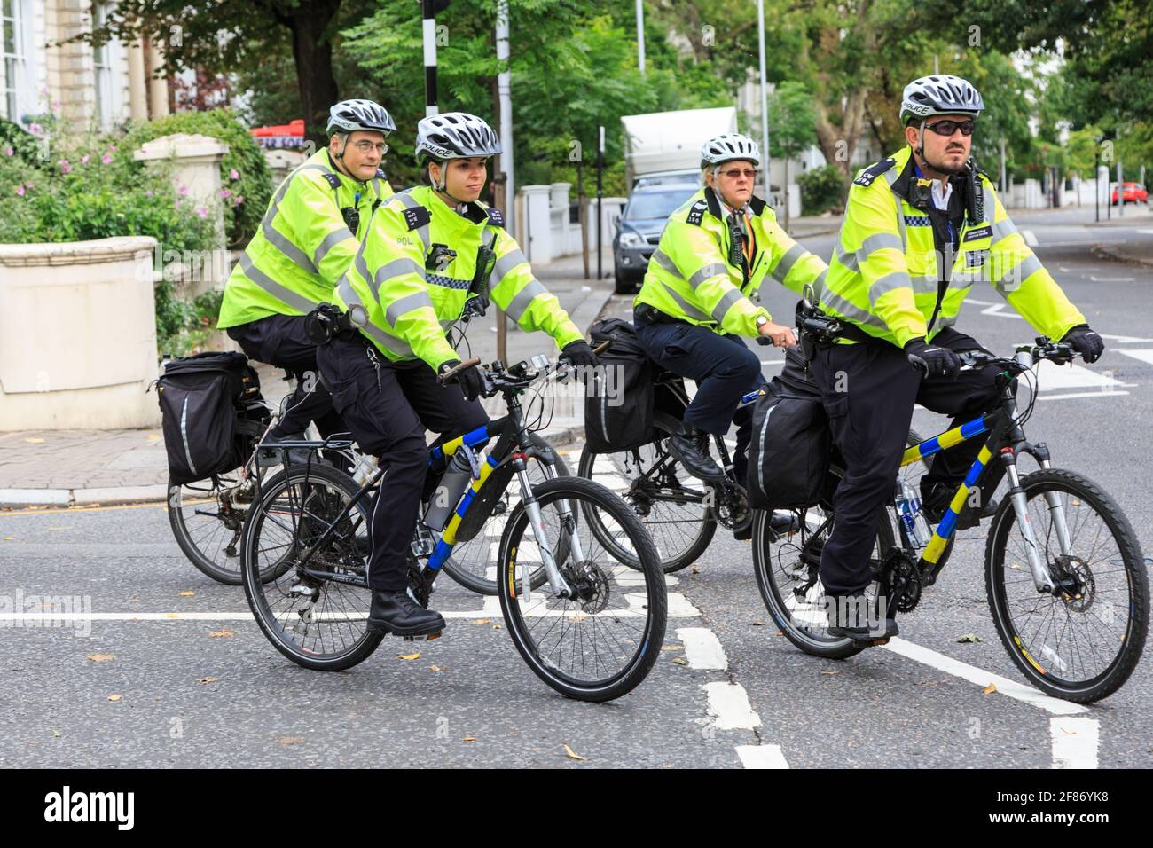 British Metropolitan Police officers on bicycles in high viz jackets, Notthing Hill, London, UK Stock Photo