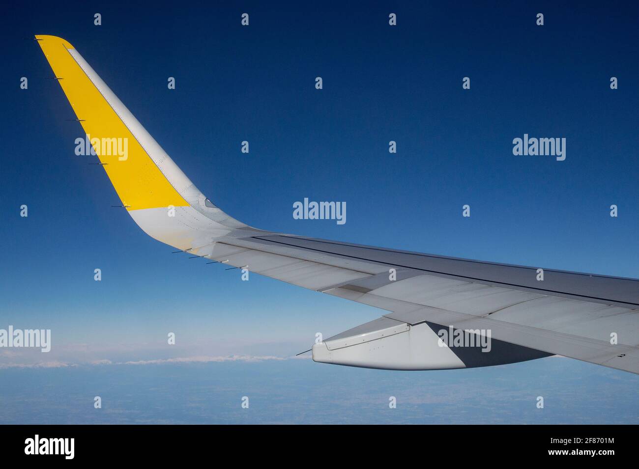 Plane with yellow marking in blue sky Stock Photo