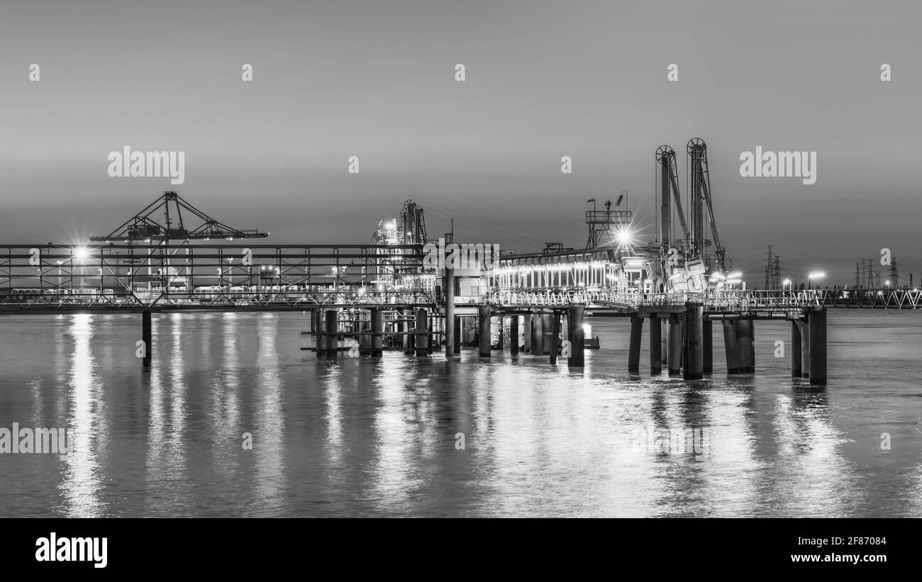 Industrial pier near petrochemical production plant during a colorful sunset, Port of Antwerp, Belgium Stock Photo