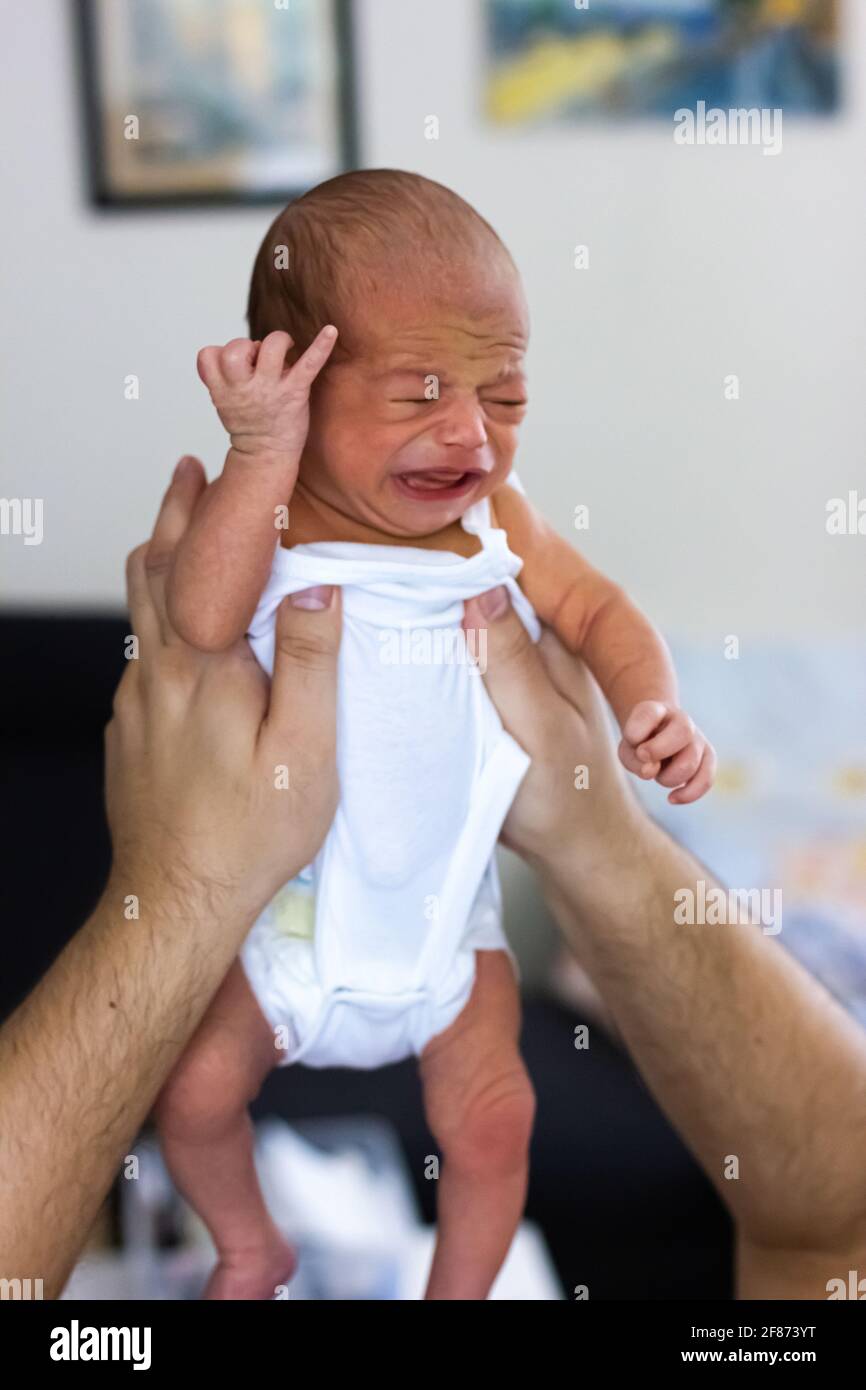 Crying newborn baby. Very cute baby boy in father's hands Stock ...
