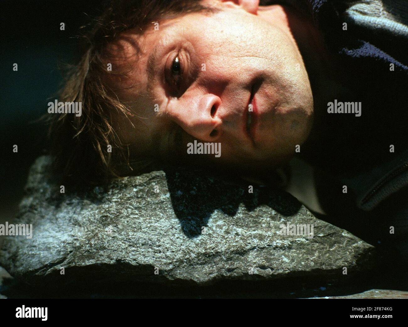 Simon Mcburney on stage at the Riverside Studios, with his head on a rock, which is used during performances, and he regards as the sort of technology that appeals to him. Stock Photo