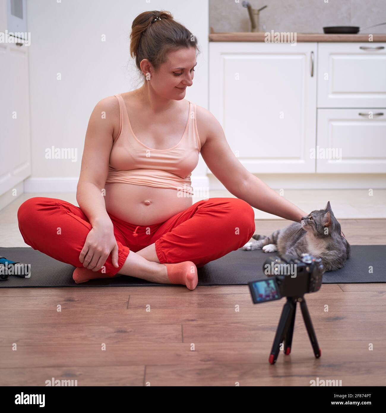 Sports at home during pregnancy and shooting videos on the camera. Pregnant  woman on fitness workout leads online stream Stock Photo - Alamy