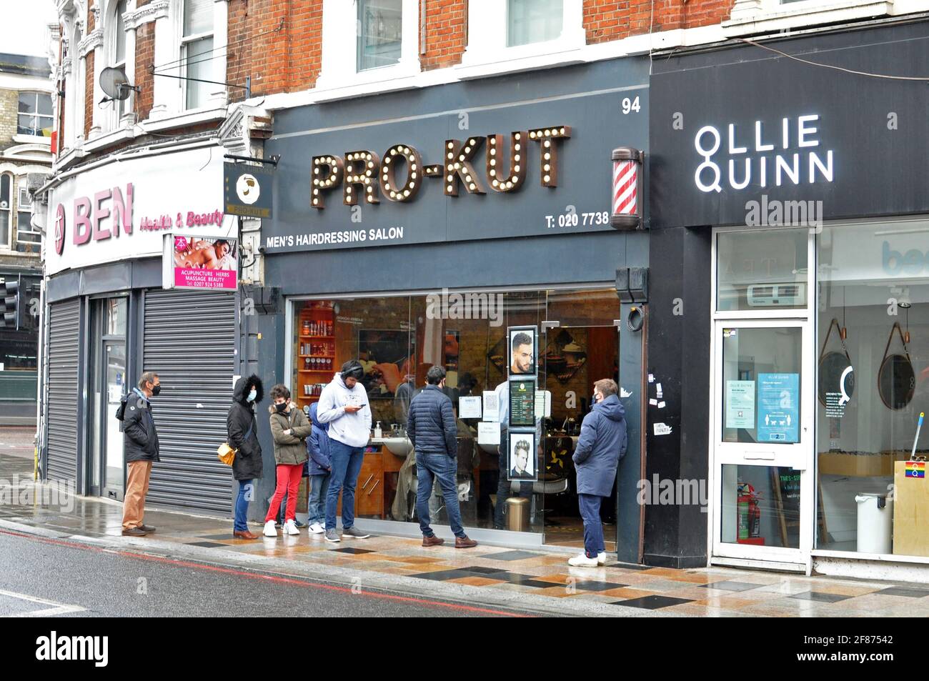 London, UK. 12th Apr, 2021. Queue at barber shop Pro-Kut under the flat where J K Rowling started to write Harry Potter. Slow start to easing of lockdown restrictions at Clapham Junction, Battersea as rain falls. Credit: JOHNNY ARMSTEAD/Alamy Live News Stock Photo