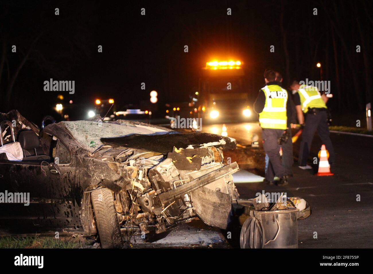 Kolkwitz, Germany. 12th Apr, 2021. Police officers are standing by a badly damaged car on the L49 road. A man caused an accident in Kolkwitz (Spree-Neisse district) while trying to evade a traffic control - his passenger was fatally injured. Credit: -/BLP/dpa/Alamy Live News Stock Photo