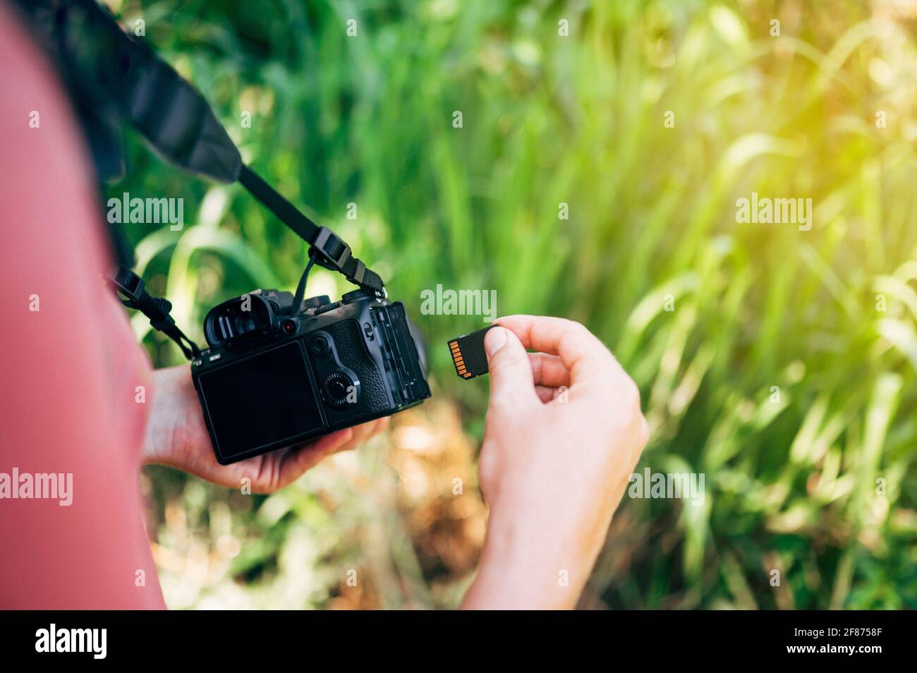 Photographer inserting the memory card into the camera Stock Photo