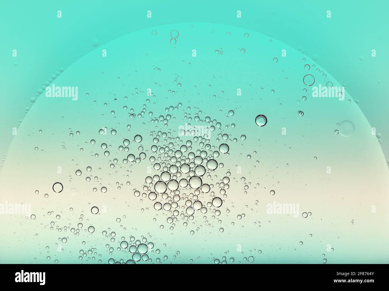 Circular globular oil bubbles floating on the surface of of green tinted water creating a random pattern with copyspace for a design template Stock Photo