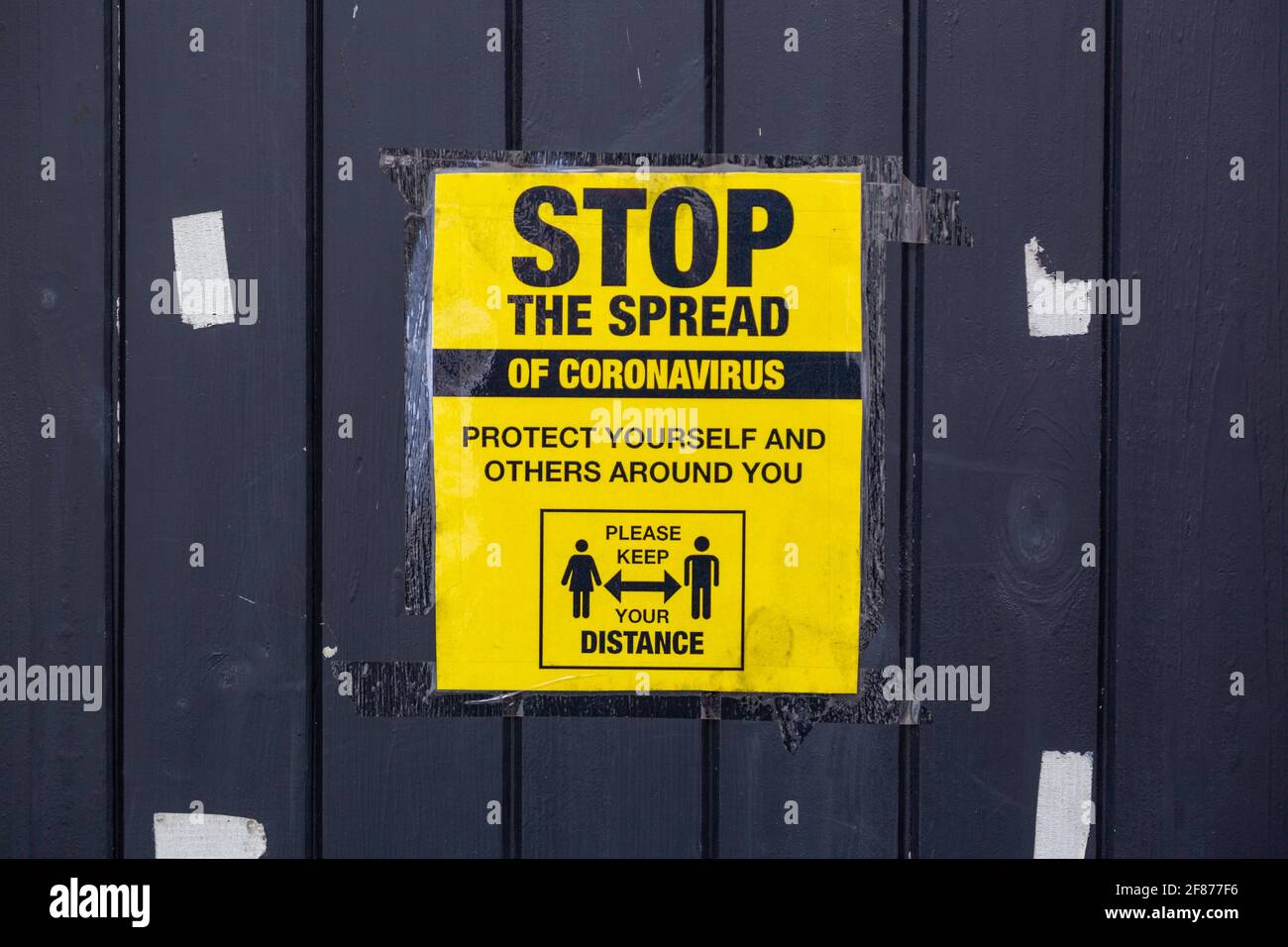 A sign on the exterior of a building outlining social distancing measures during the coronavirus or covid pandemic Stock Photo