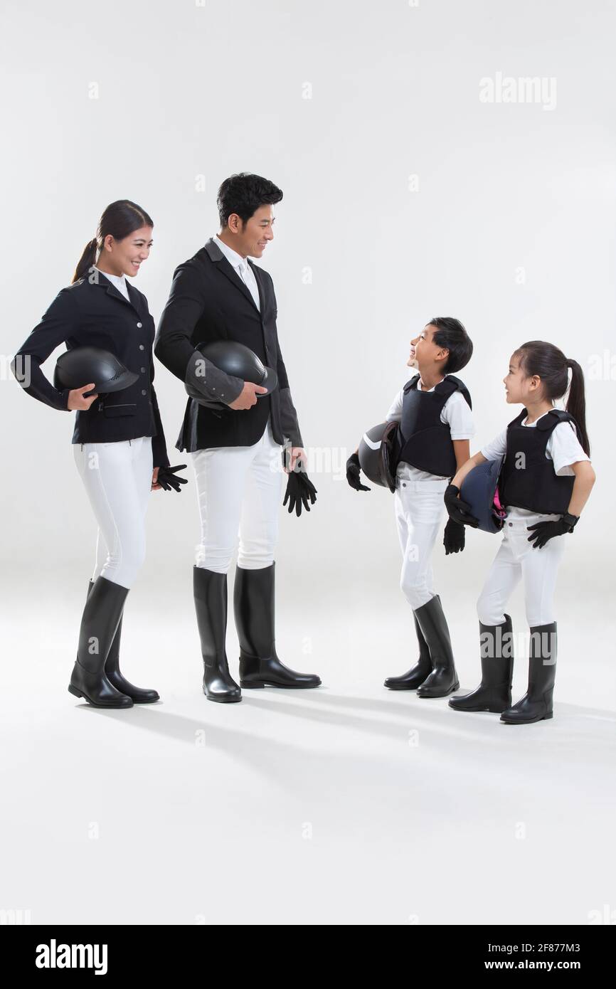 Happy young family in riding clothes Stock Photo Alamy