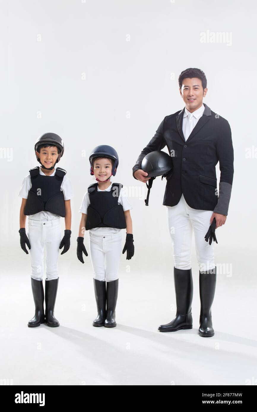 Happy young family in riding clothes Stock Photo Alamy