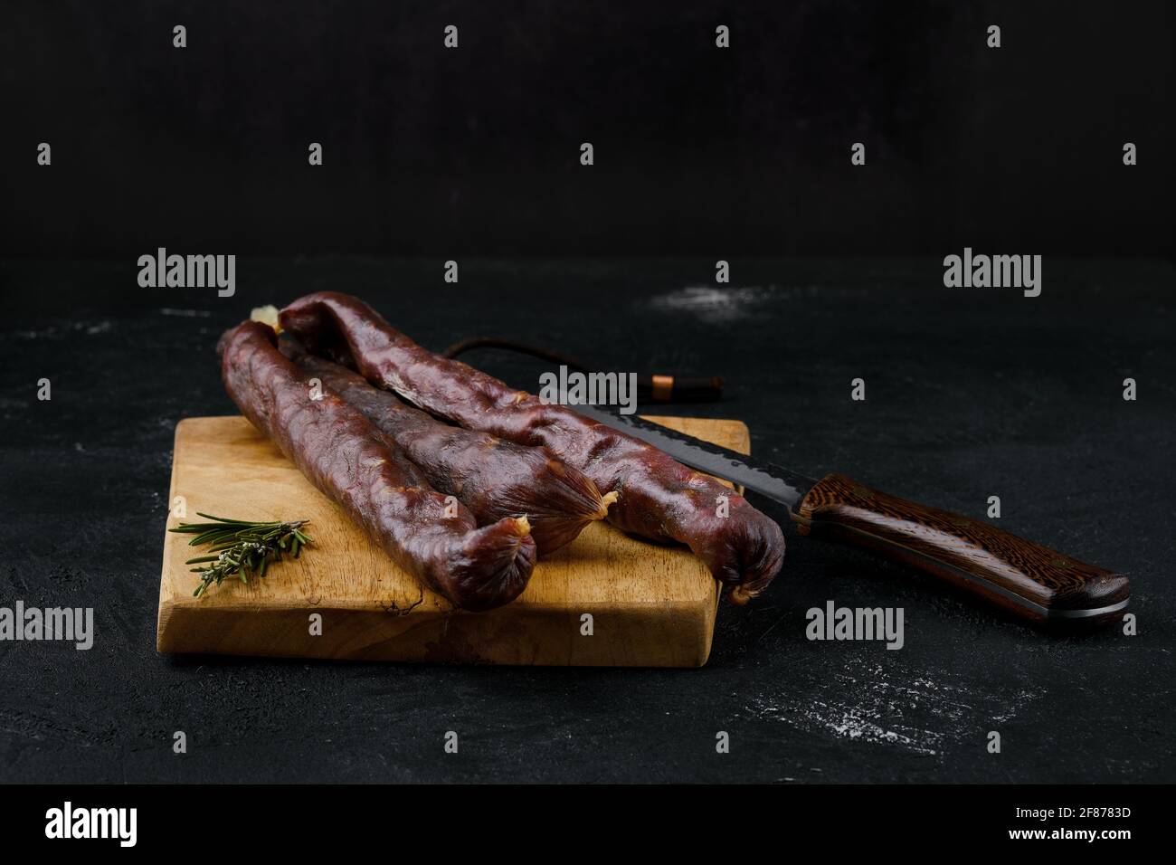 Dry cured beef sausage on cutting board Stock Photo
