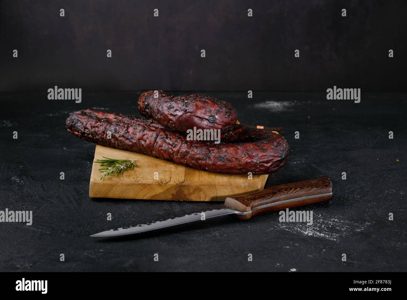Smoked beef sausage on cutting board Stock Photo