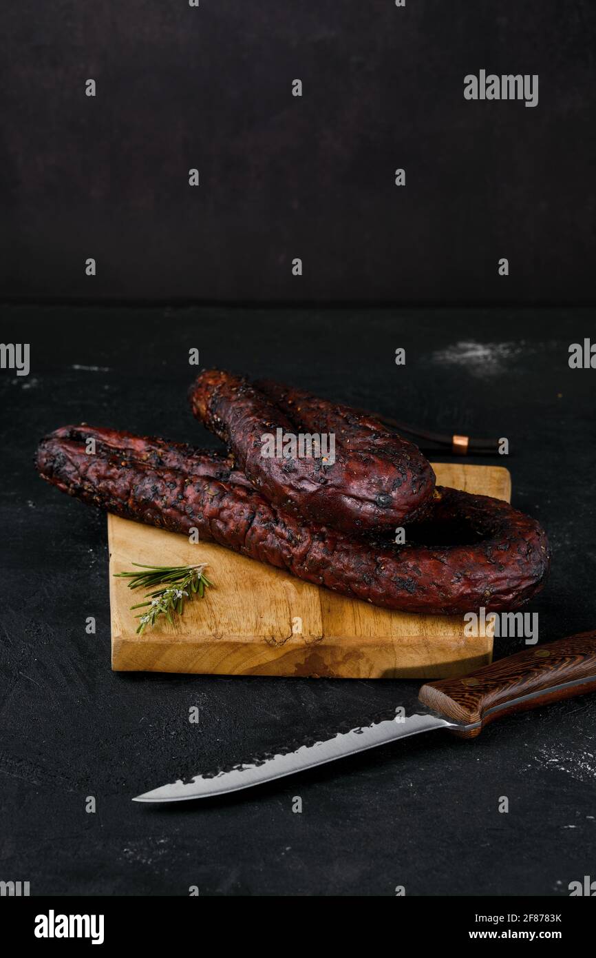Smoked beef sausage on cutting board Stock Photo
