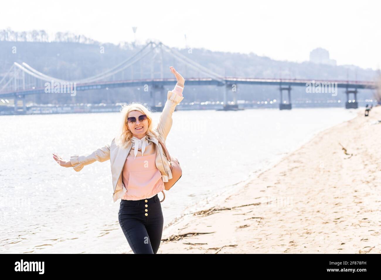 young woman raising arms up towards blue sky and river Stock Photo - Alamy
