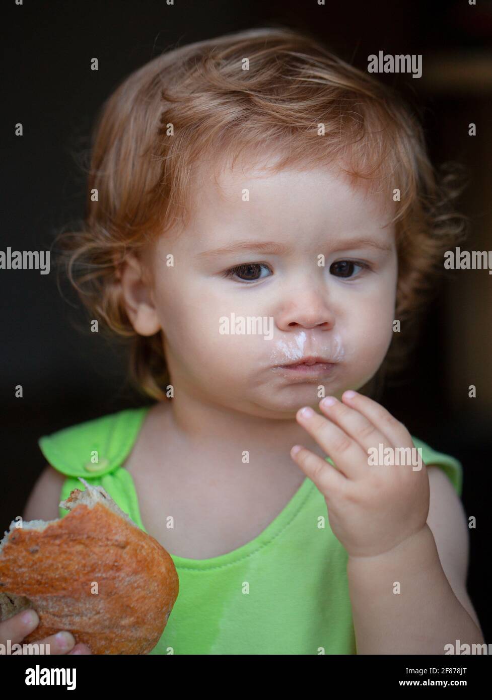 Cute toddler child eating sandwich, self feeding concept. Stock Photo