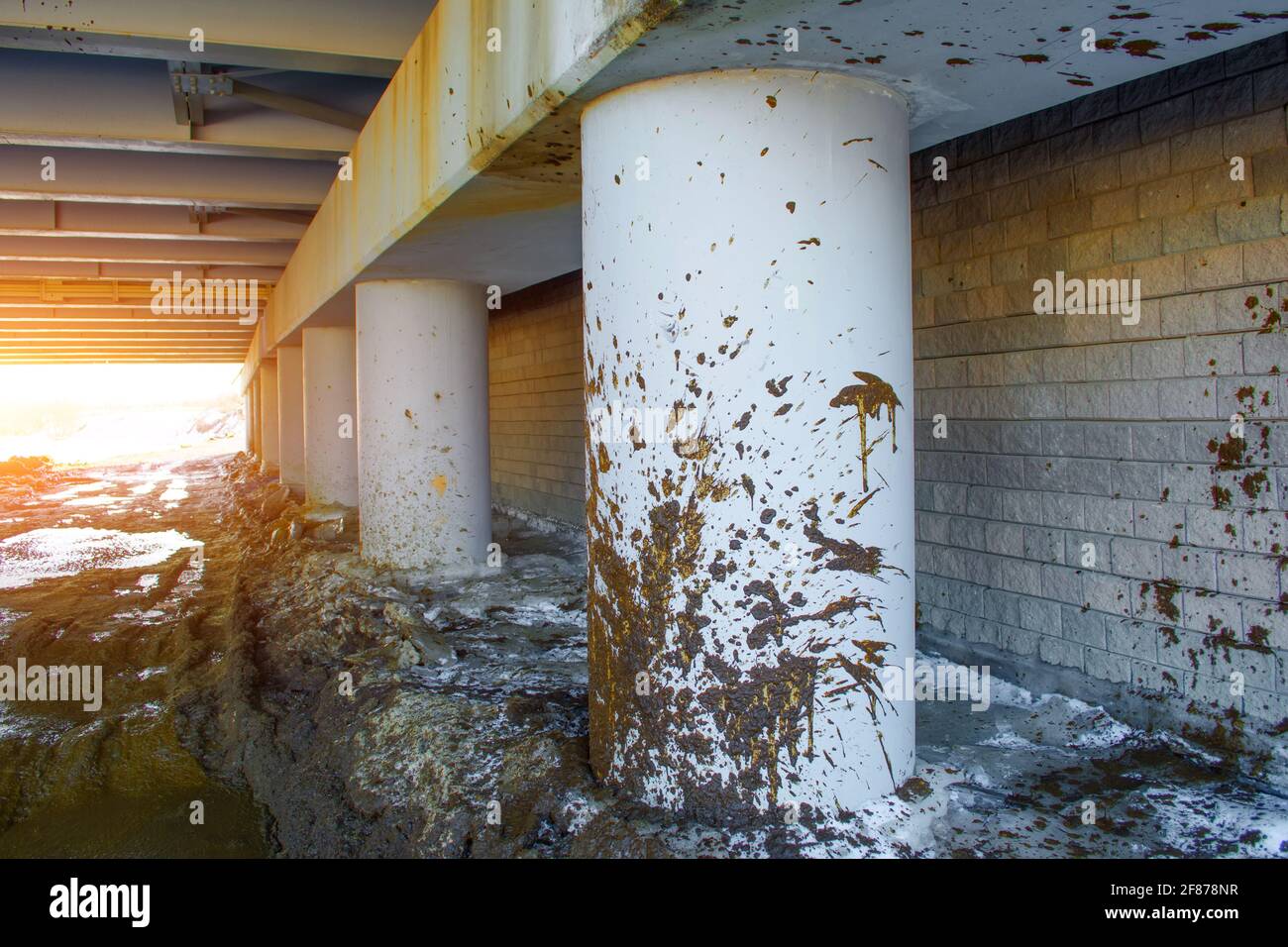Spray dirt on poles under the bridge on an impassable road Stock Photo