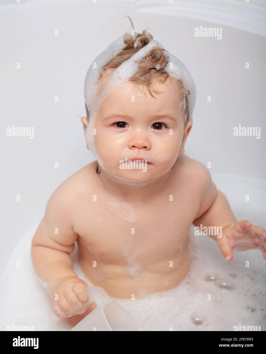 Kid bathing in bathtub. Little baby taking bath, closeup face portrait
