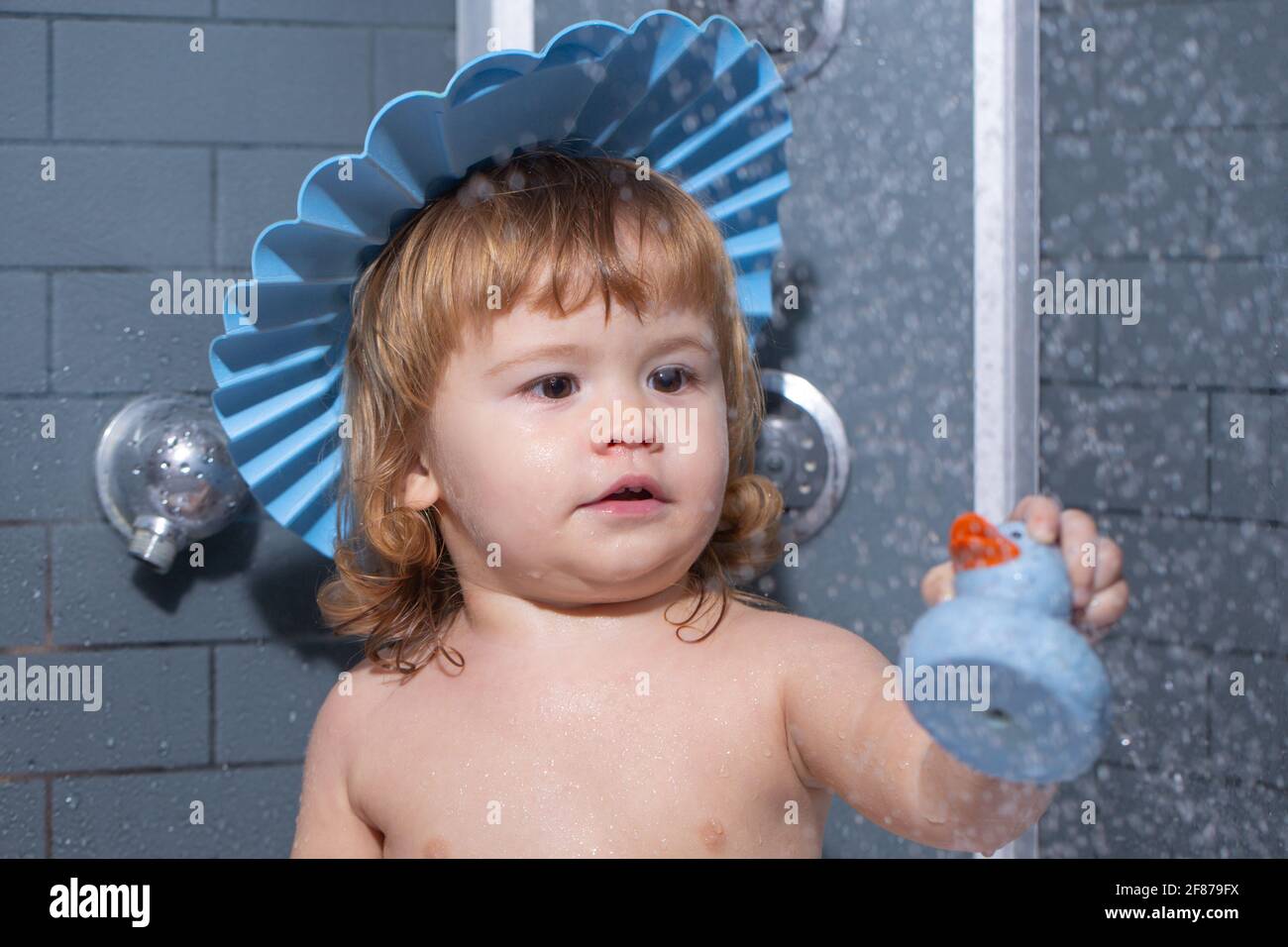 Child in bathroom play with foam. Little baby taking bath, closeup face
