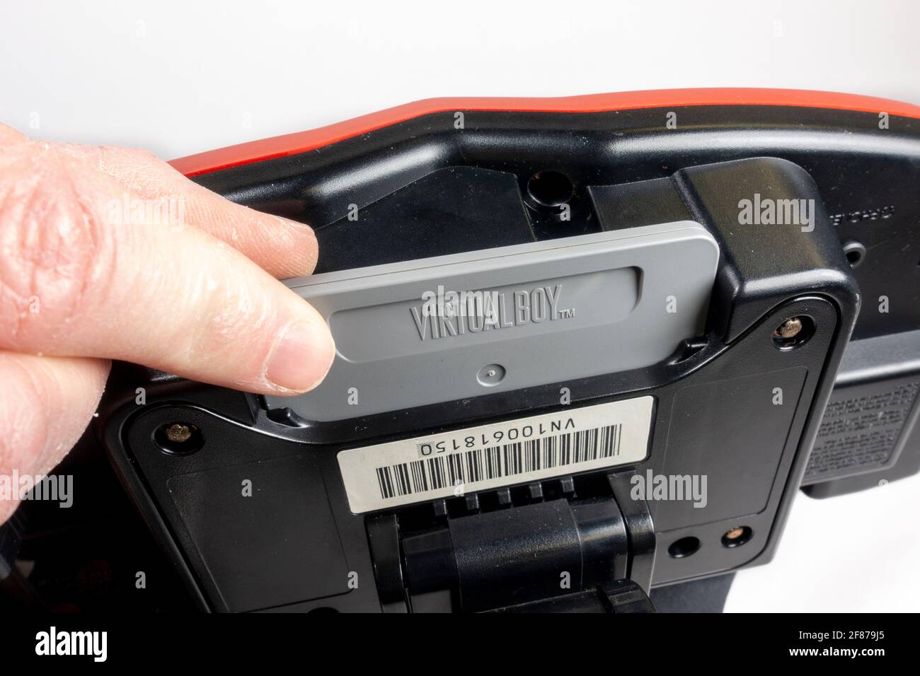 Cartridge in the slot of a Nintendo Virtual Boy table-top video game console, first launched in Japan in 1995, (it did not launch in Europe). Stock Photo