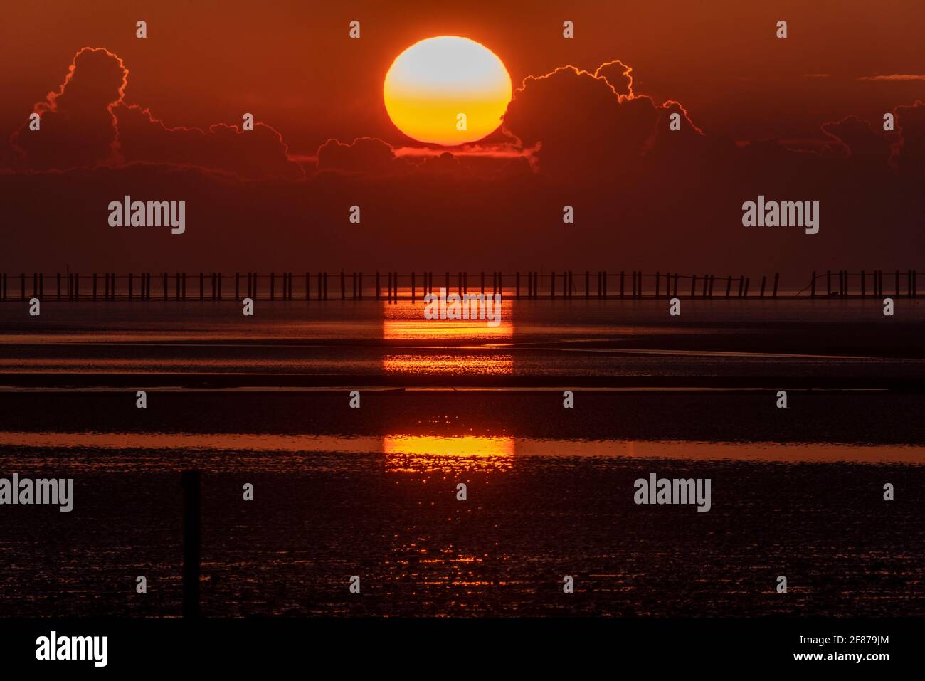 Sunrise over anti submarine boom at Shoeburyness, Essex, UK. Stretching