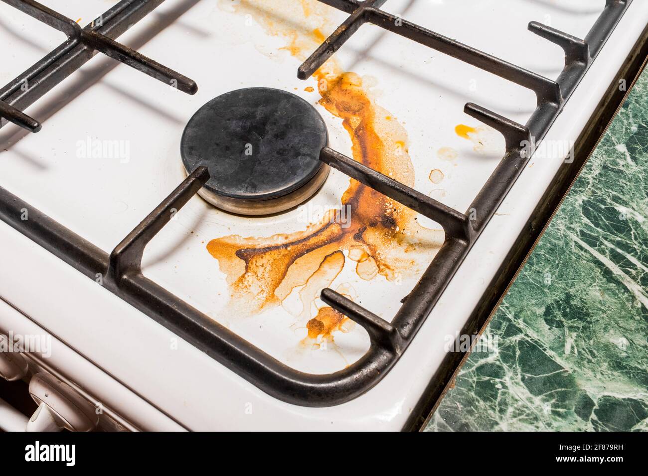 Dirty gas stove and burners after home cooking in the kitchen, close up