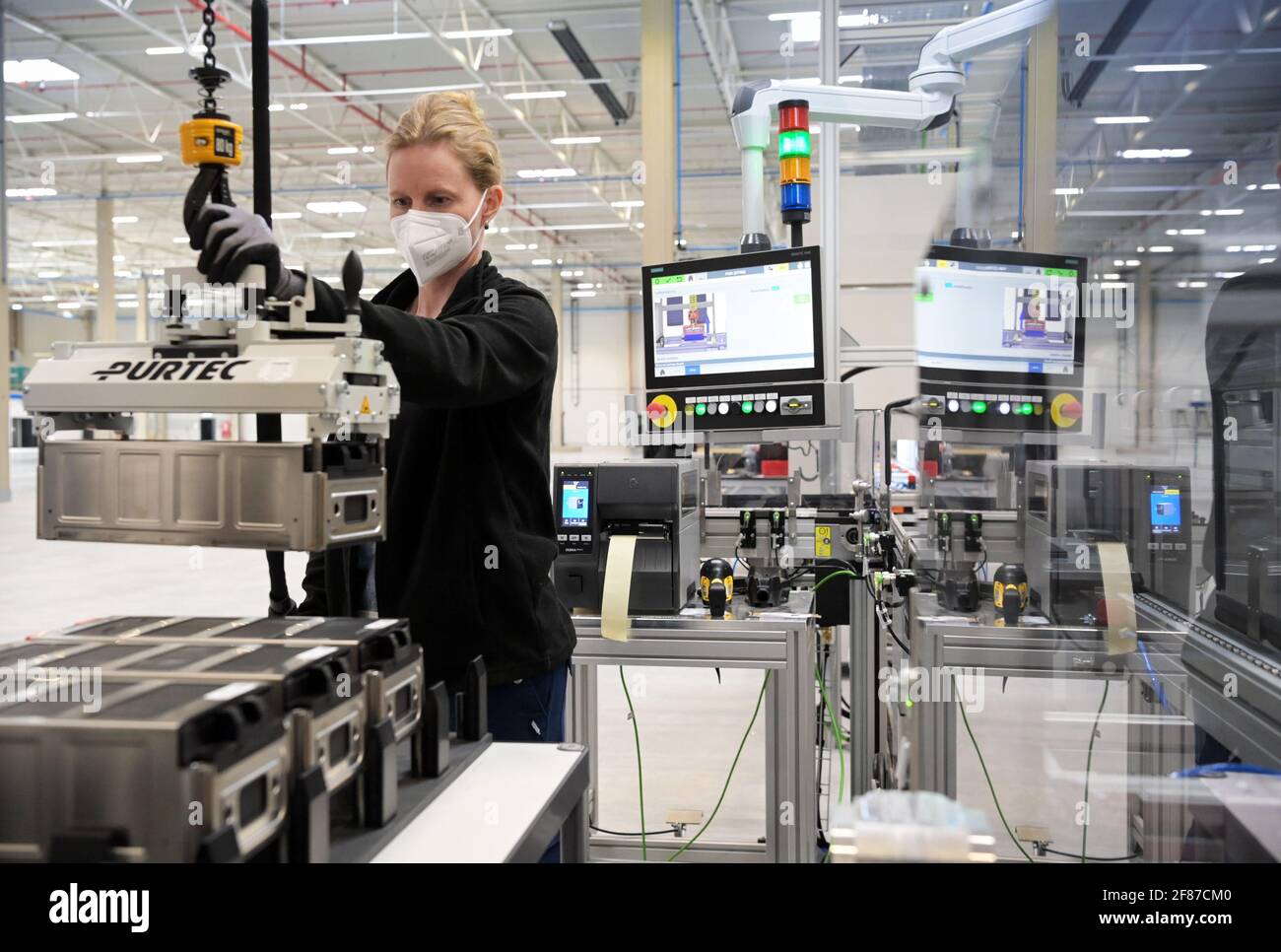 Ludwigsfelde, Germany. 24th Mar, 2021. Nicole Fischer, an employee of the  US battery manufacturer Microvast, sets down a battery module during the  end-of-line test. The company produces lithium-ion battery systems for  electrically