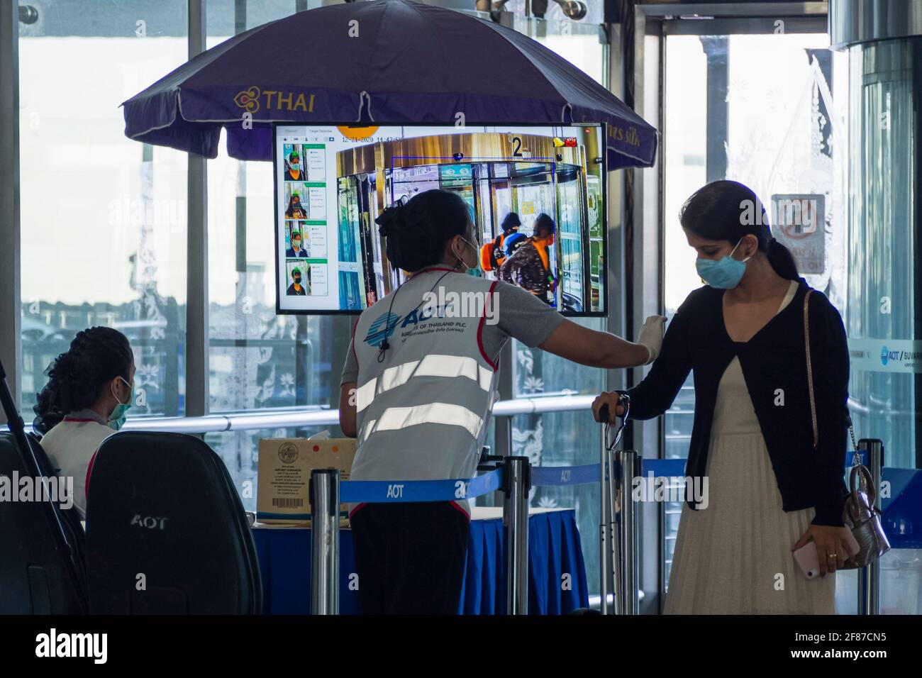Bangkok, Thailand - April 11, 2021 : airport terminal officers use thermal scanner to checking passenger temperature for covid-19 or coronavirus befor Stock Photo