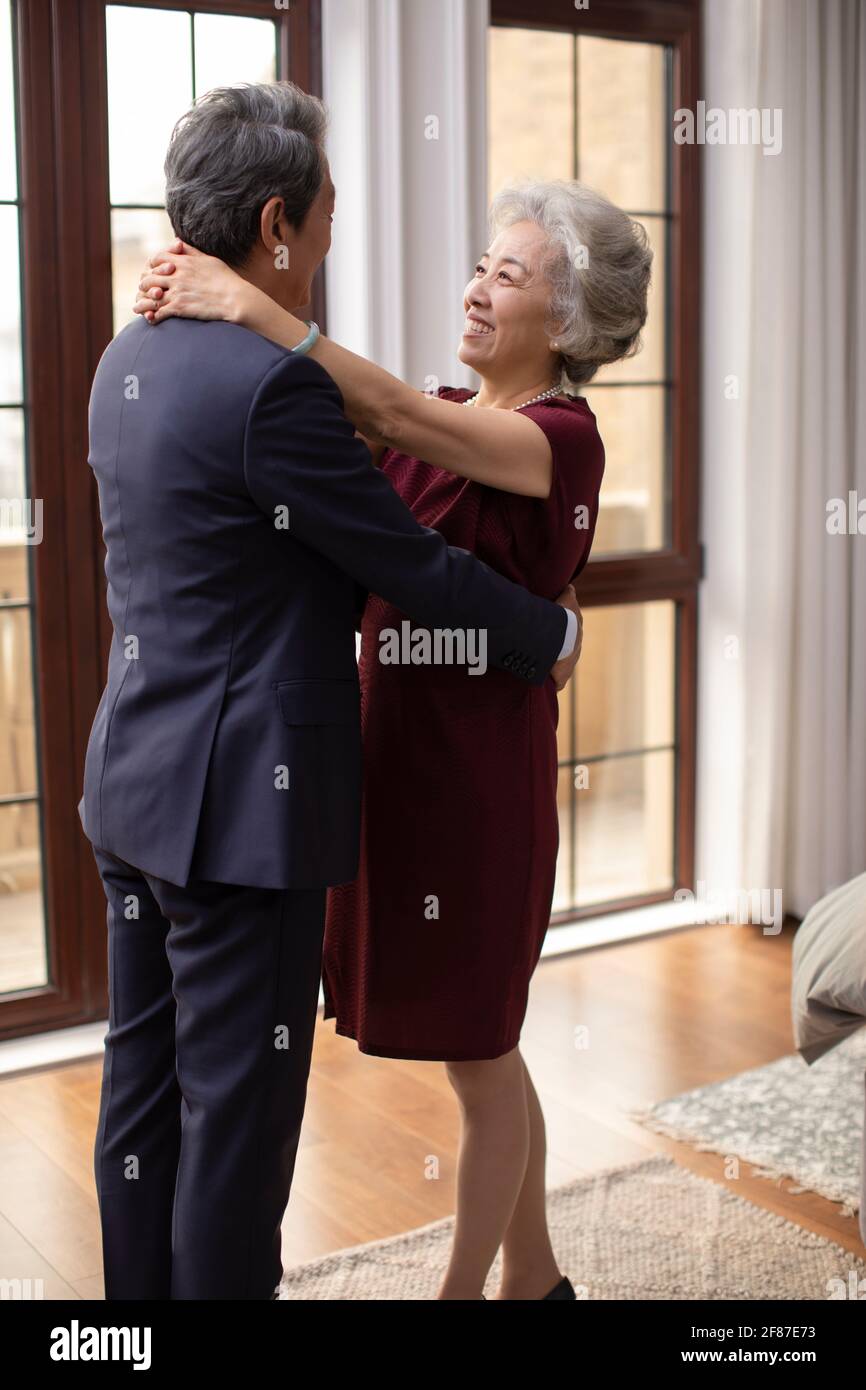 Happy senior couple embracing in bedroom Stock Photo