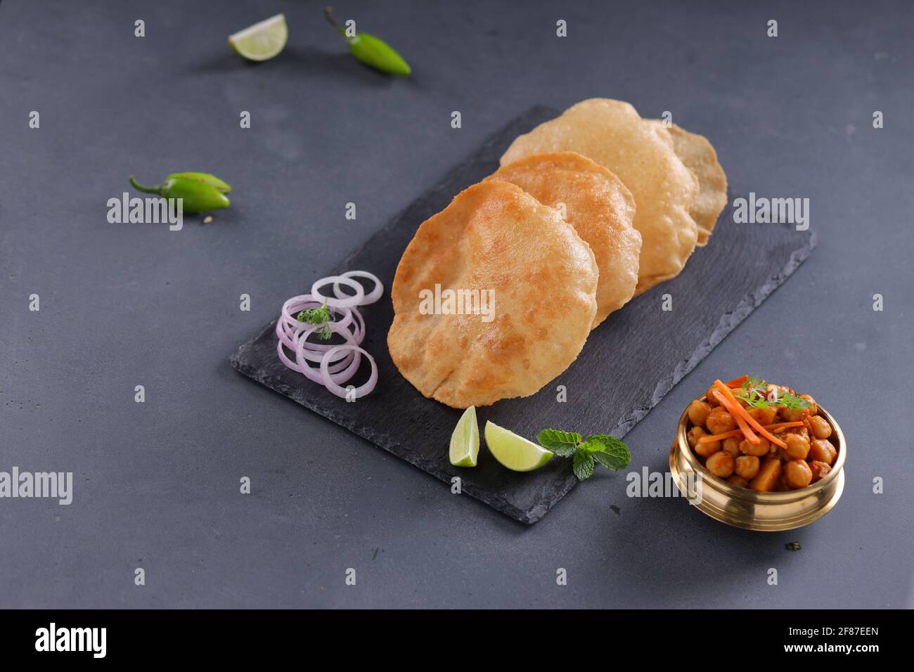 Indian breakfast  Poori or puri ,tasty indian dish made using all purpose wheat flour which is arranged in a slate with grey textured background. Stock Photo