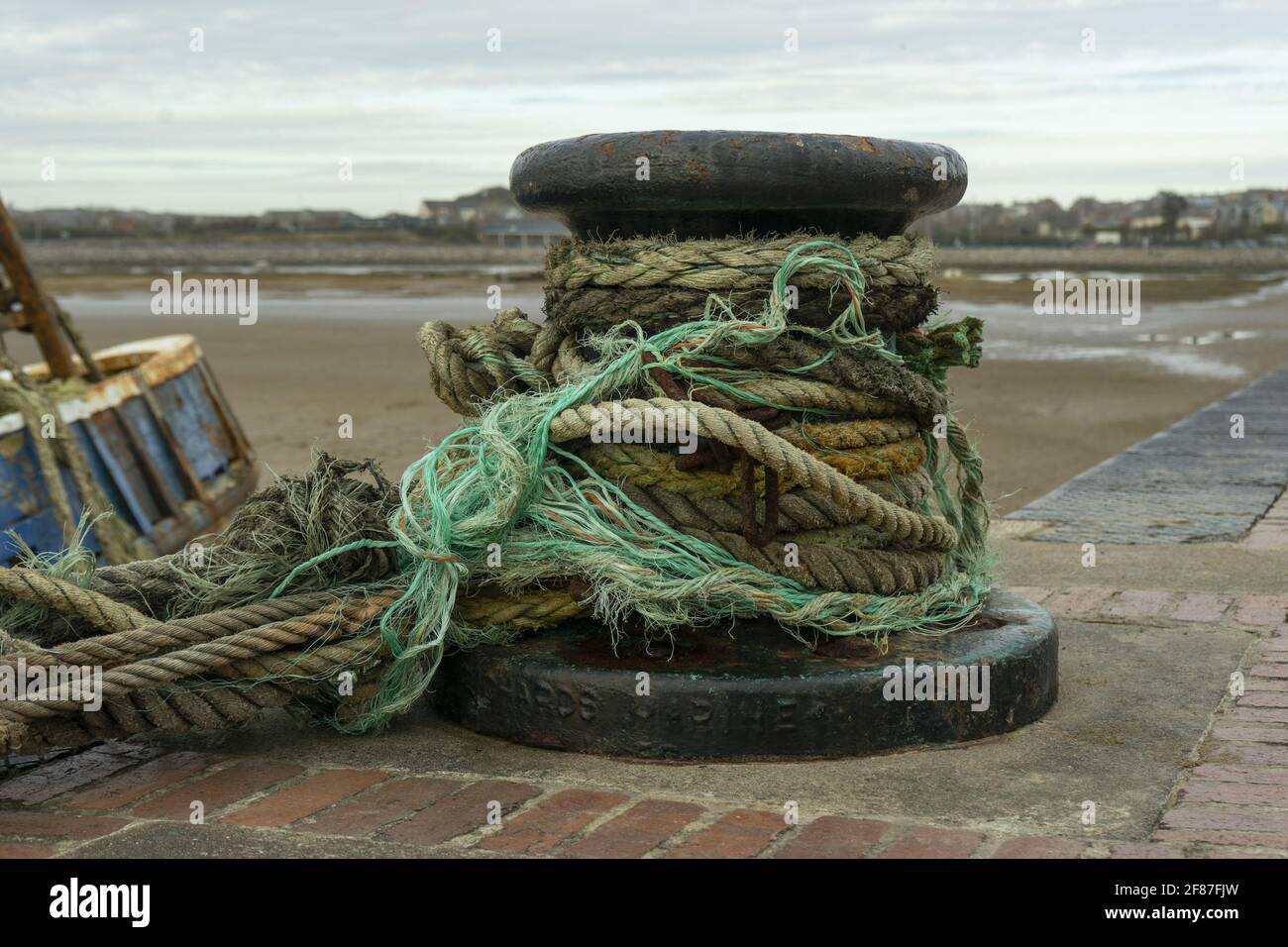 Thick mooring rope around a rusty bollard in a port Stock Photo Alamy