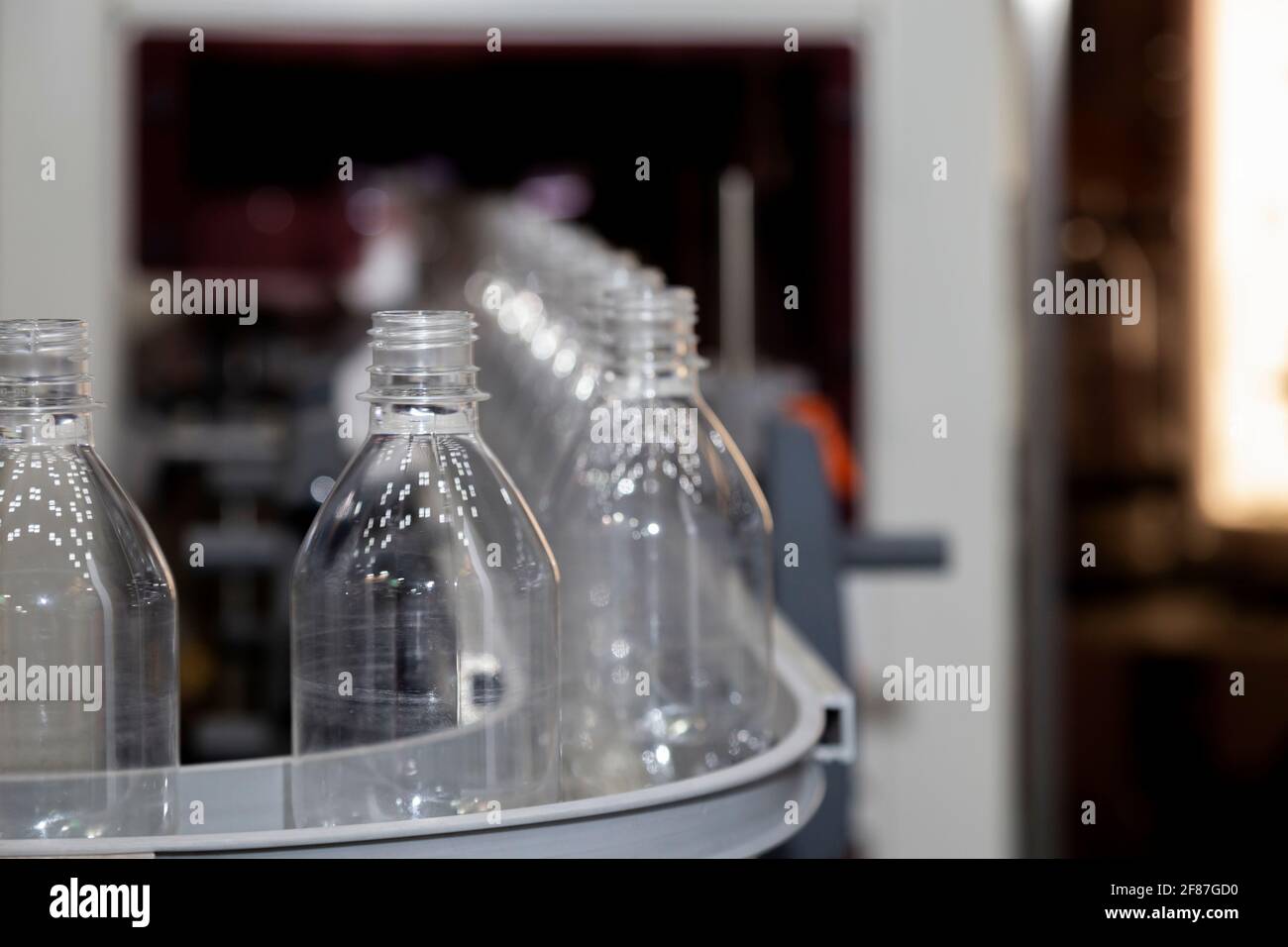 transparent plastic bottle on factory line machine in the beverage manufacturing, selective focus. Stock Photo