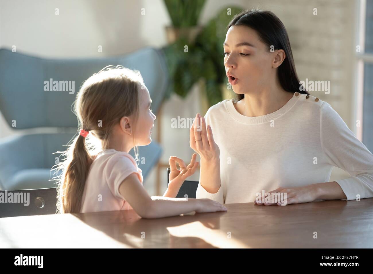 Little girl with mom learn pronouncing sounds Stock Photo