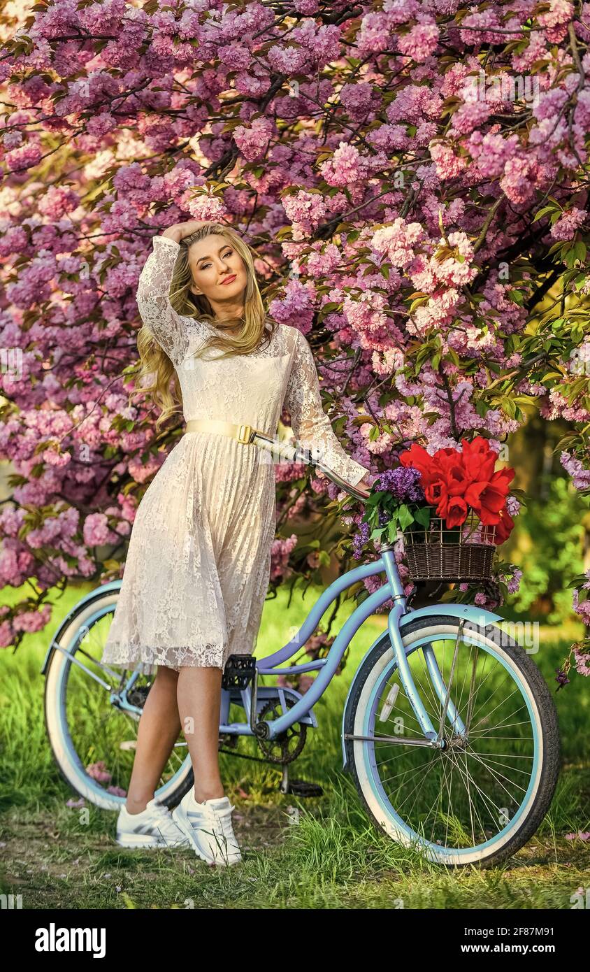 Spring in her basket. woman in garden. young fashionable girl with retro bike near cherry blossoms. girl with vintage bicycle in pink sakura alley Stock Photo Alamy