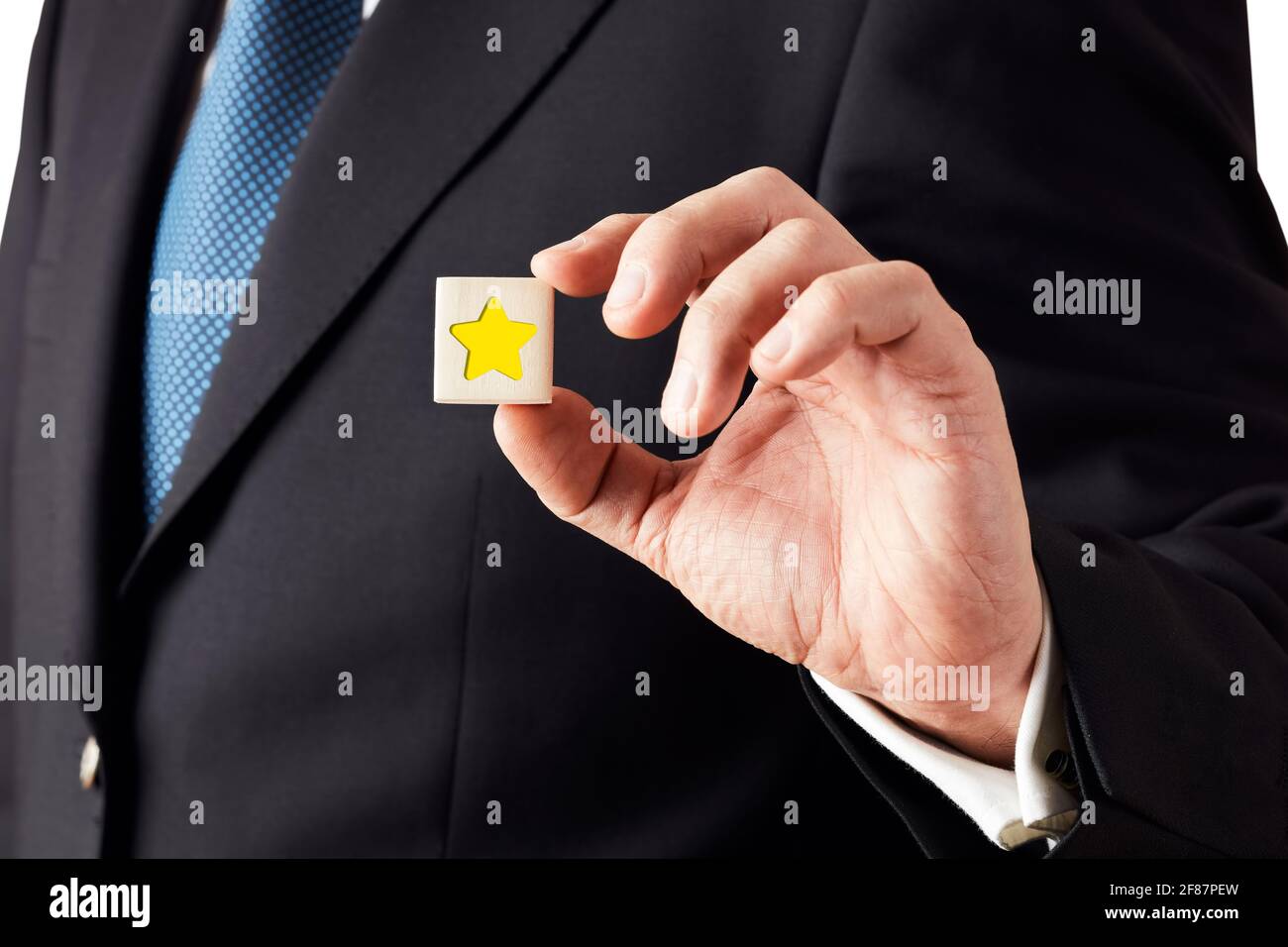 Businessman shows a wooden cube with star icon. Feedback or evaluation rating concept. Stock Photo