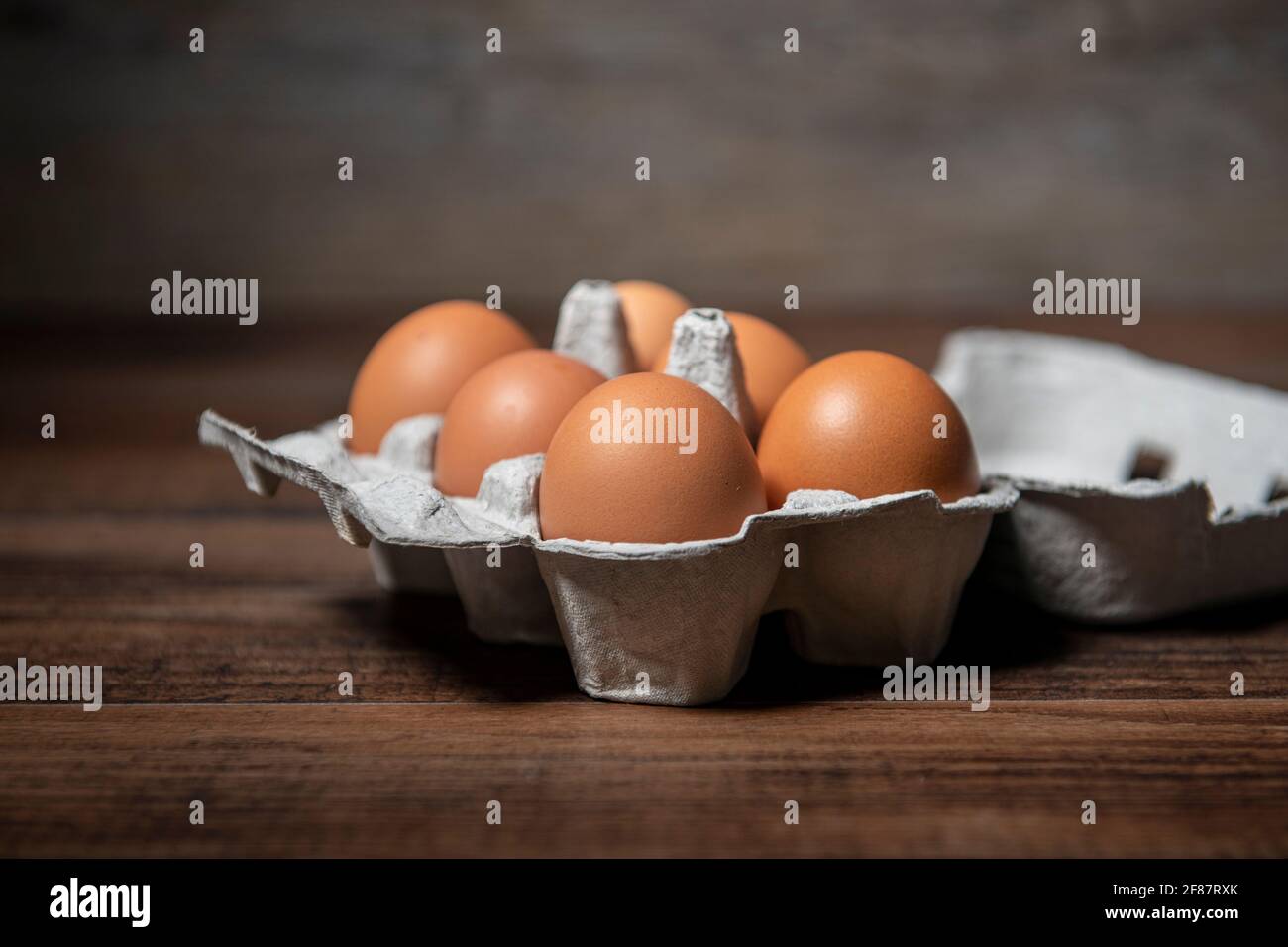 Fresh farm eggs in an eggbox on a wooden rustic table. Stock Photo
