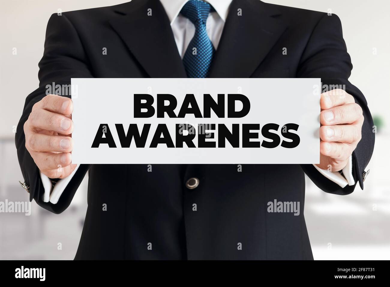 Businessman shows a banner with the message brand awareness. Business marketing strategy branding concept. Stock Photo