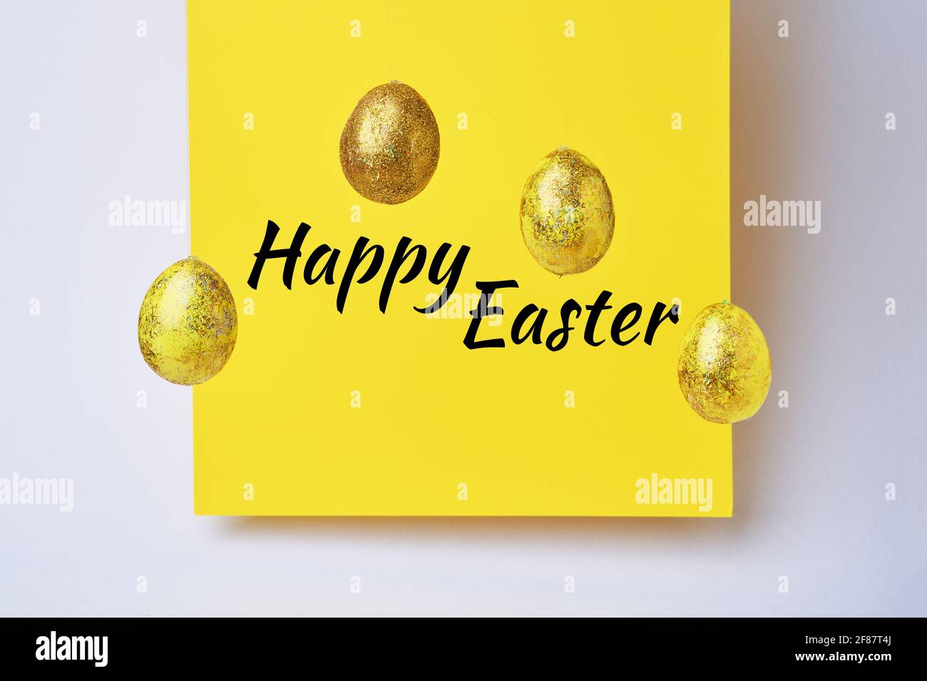 Golden shiny eggs and yellow blank with text - Happy Easter. Easter concept Stock Photo