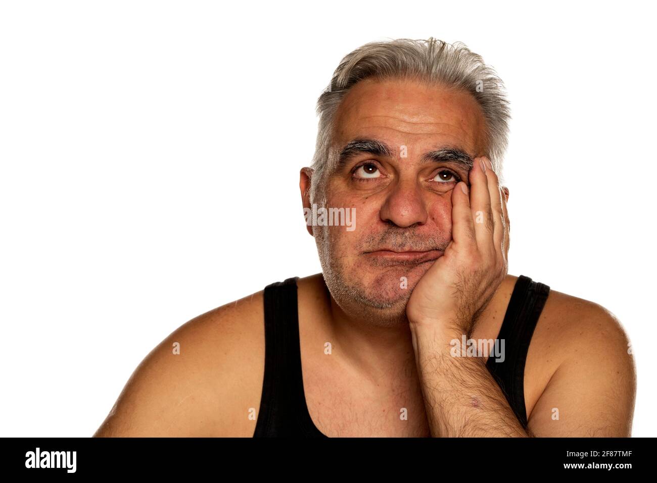 bored unshaven middle aged man with short gray hair Stock Photo