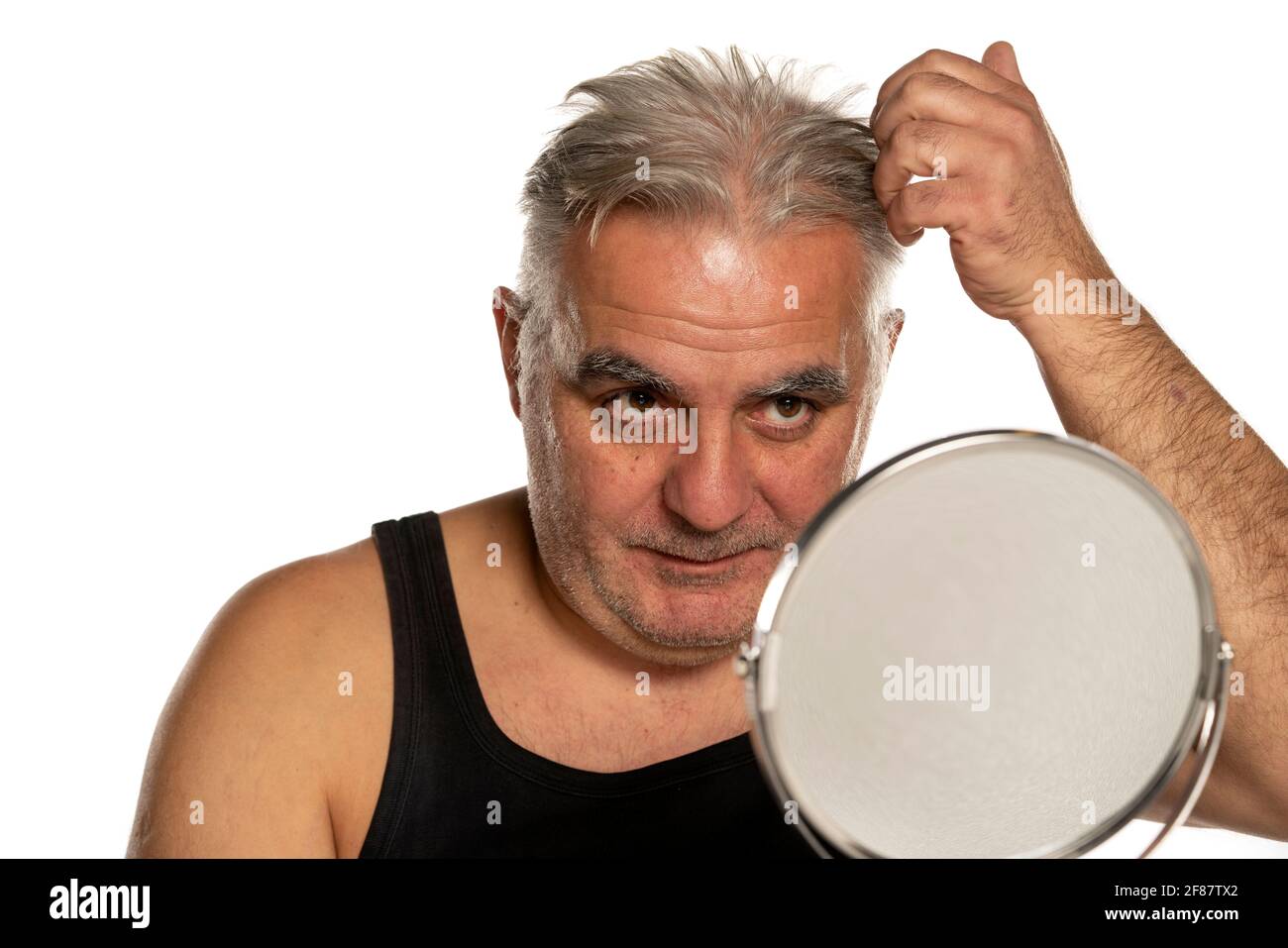 concerned middle aged man with short gray hair on white background Stock Photo