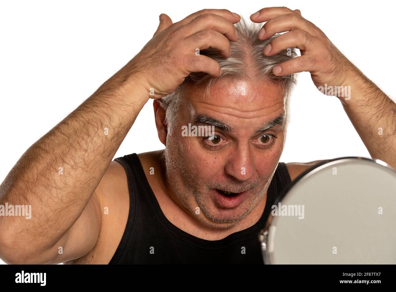 shocked middle aged man with short gray hair on white background Stock Photo